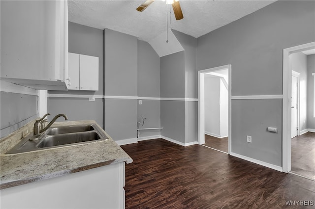 kitchen with white cabinets, a textured ceiling, dark hardwood / wood-style floors, and sink