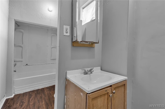 bathroom featuring wood-type flooring, vanity, and  shower combination