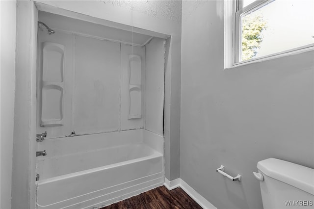 bathroom featuring hardwood / wood-style flooring, toilet, and shower / bathtub combination