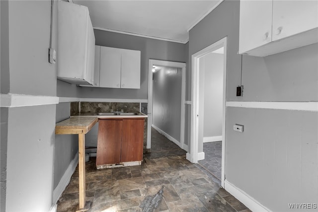 kitchen featuring crown molding and white cabinetry