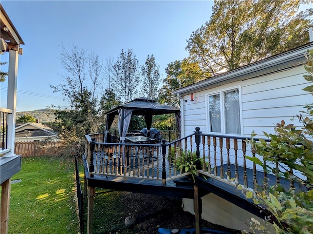 wooden deck featuring a gazebo and a yard