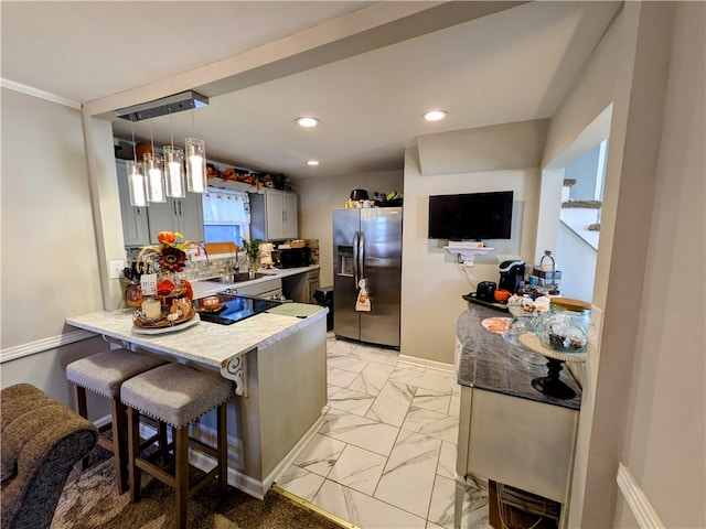 kitchen featuring gray cabinetry, kitchen peninsula, a kitchen bar, decorative light fixtures, and stainless steel refrigerator with ice dispenser