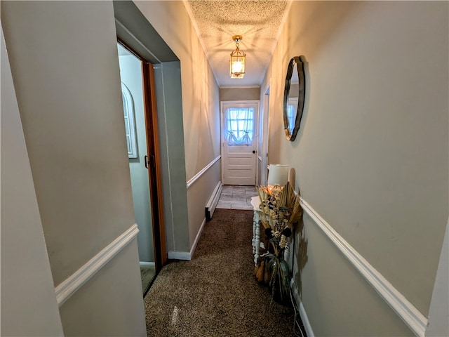 hall featuring a textured ceiling and carpet flooring