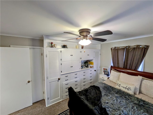 carpeted bedroom featuring ceiling fan, a closet, and crown molding