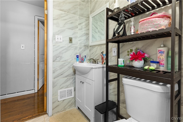 bathroom featuring tile walls, vanity, and toilet