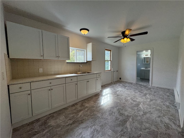 kitchen with ceiling fan, sink, decorative backsplash, and white cabinetry