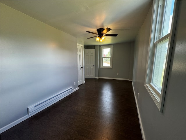 empty room with ceiling fan, baseboard heating, and dark wood-type flooring