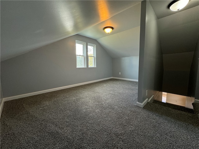 bonus room with vaulted ceiling and carpet flooring