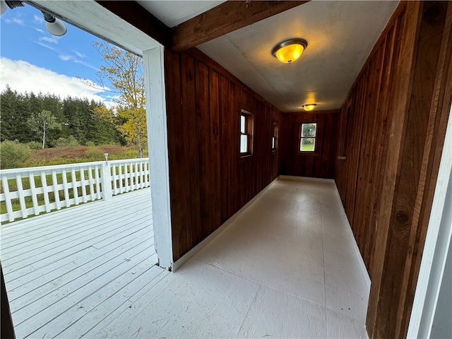 hall featuring wooden walls, beam ceiling, and light hardwood / wood-style flooring