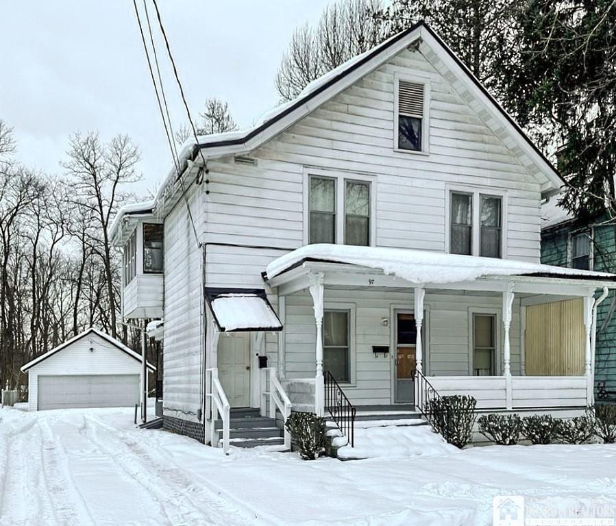 view of front of property featuring a garage, an outdoor structure, and covered porch