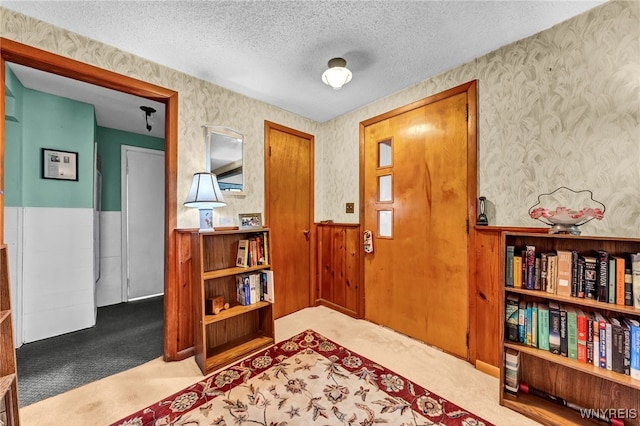 carpeted foyer featuring a textured ceiling