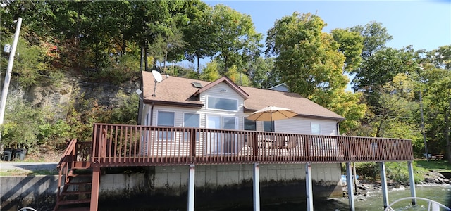 rear view of house featuring a deck with water view