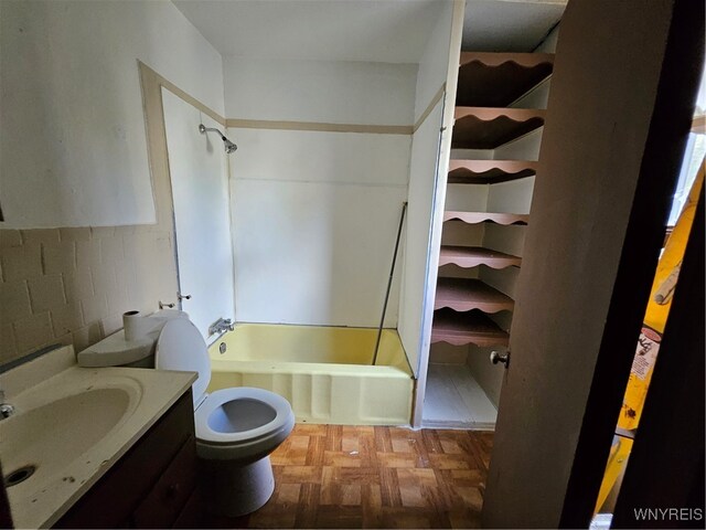 full bathroom with tub / shower combination, vanity, parquet flooring, and toilet