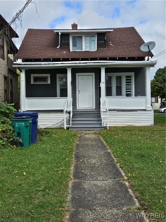 bungalow-style house featuring a front yard and covered porch