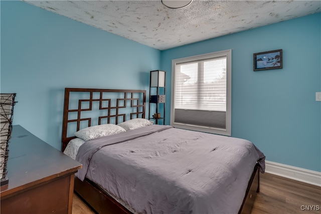 bedroom featuring hardwood / wood-style flooring and a textured ceiling