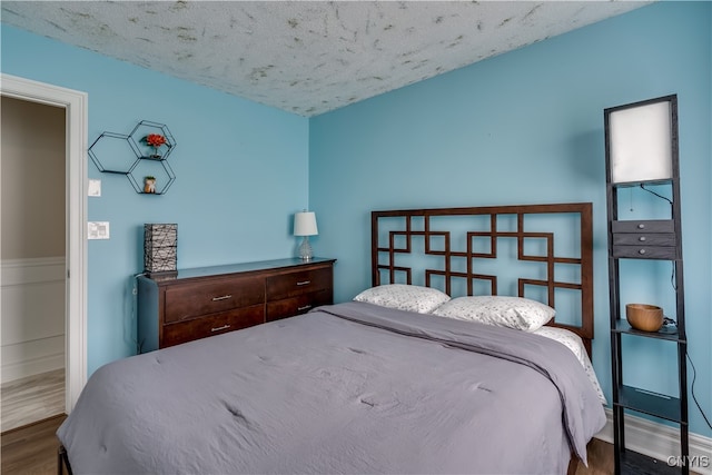 bedroom featuring wood-type flooring and a textured ceiling