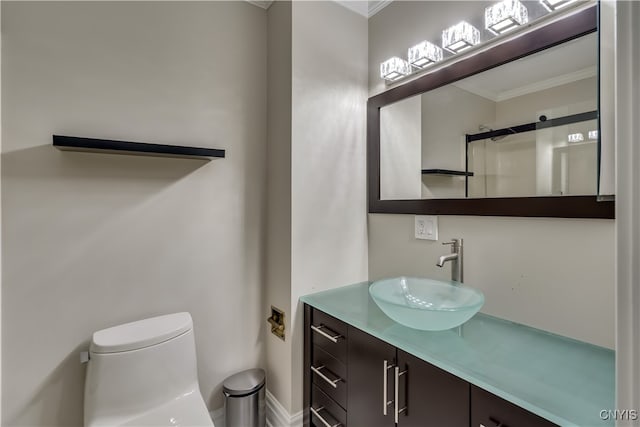 bathroom with crown molding, vanity, walk in shower, and toilet