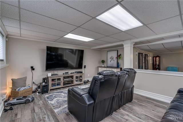 living room with a drop ceiling, crown molding, and hardwood / wood-style floors