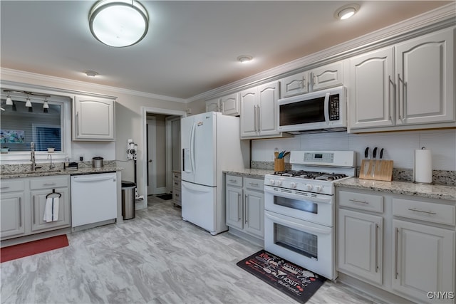 kitchen featuring light stone countertops, tasteful backsplash, white appliances, sink, and ornamental molding