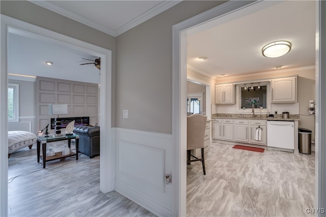 hallway with ornamental molding, light hardwood / wood-style flooring, and sink