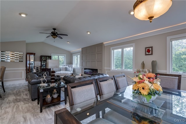 living room featuring a healthy amount of sunlight, a fireplace, and vaulted ceiling