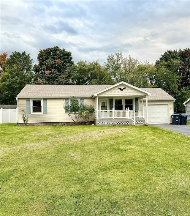 ranch-style home with a garage, a front lawn, and covered porch