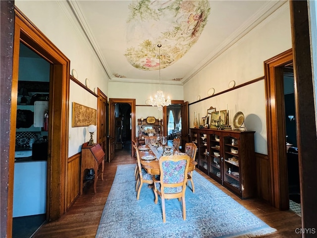 dining room with wood walls, ornamental molding, dark hardwood / wood-style floors, and a notable chandelier