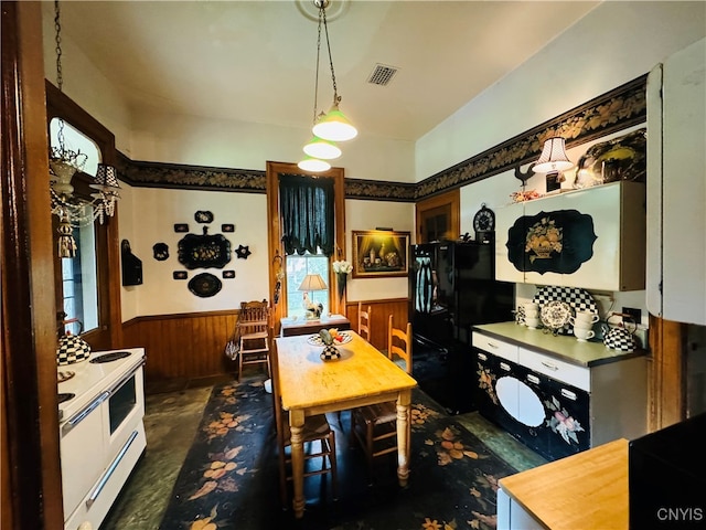 kitchen with black fridge, hanging light fixtures, plenty of natural light, and white stove