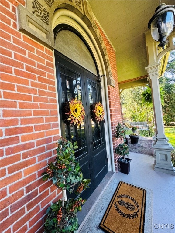 view of exterior entry featuring covered porch