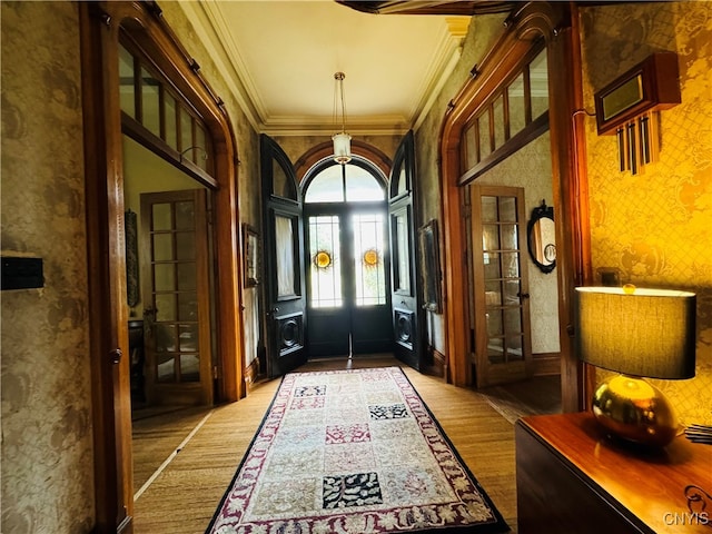 entryway featuring wood-type flooring and crown molding