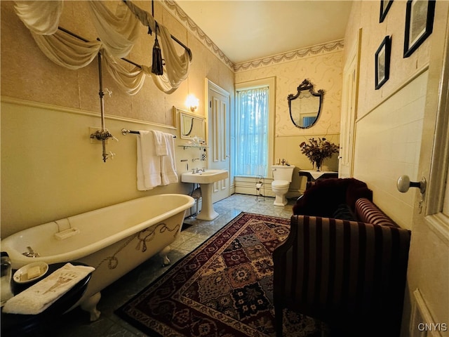 bathroom featuring sink, toilet, and a washtub