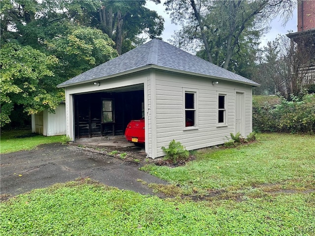 view of outbuilding with a garage and a yard