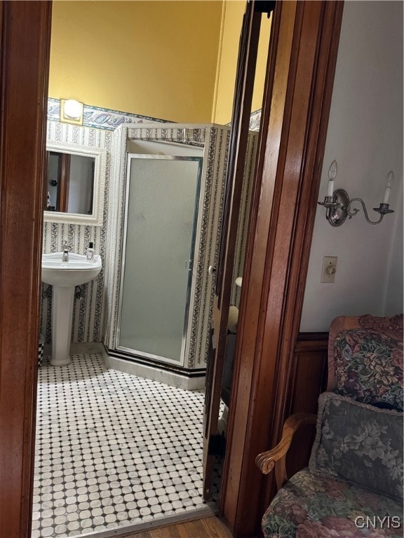 bathroom with a shower with shower door and sink