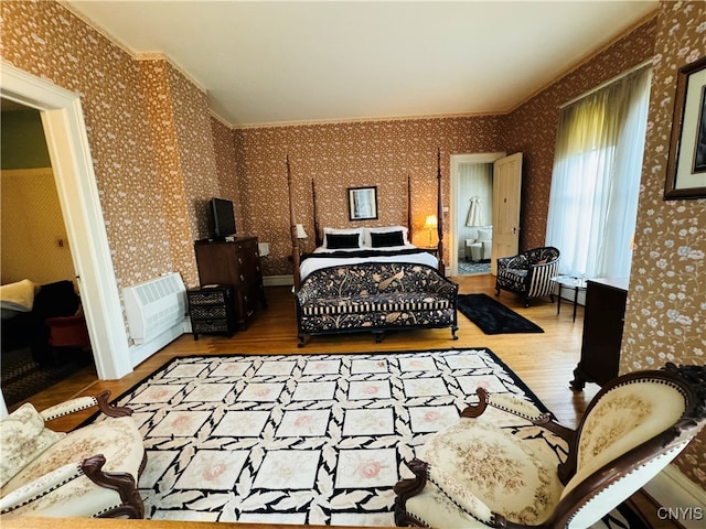 bedroom featuring ornamental molding and hardwood / wood-style floors