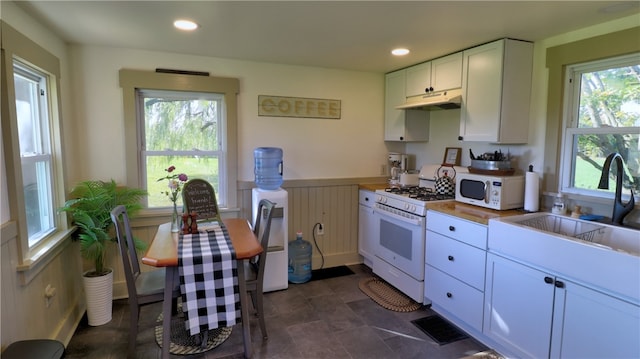 kitchen featuring white appliances, white cabinets, sink, and wooden counters