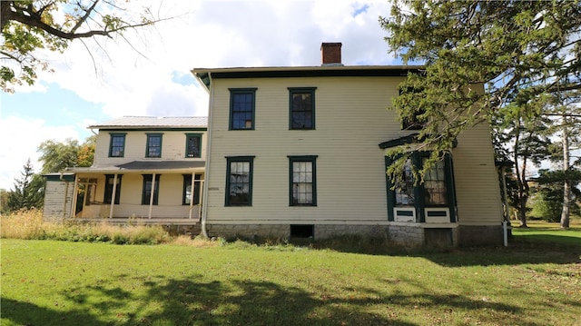 back of property featuring a lawn