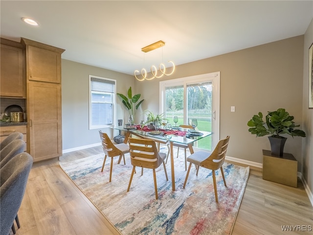 dining area featuring an inviting chandelier and light hardwood / wood-style flooring