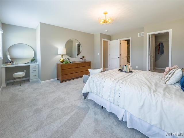 bedroom featuring a spacious closet, a closet, and light carpet