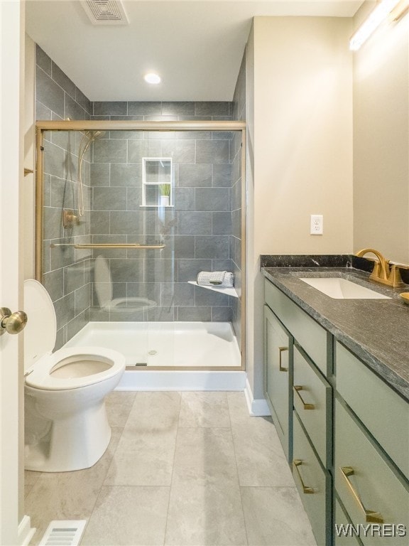 bathroom featuring tile patterned floors, a shower with shower door, vanity, and toilet