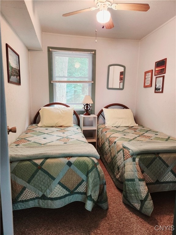 carpeted bedroom featuring ornamental molding and ceiling fan