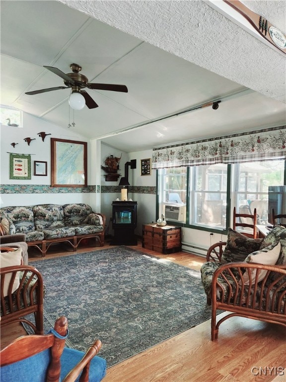 living room featuring a wood stove, hardwood / wood-style flooring, cooling unit, and ceiling fan