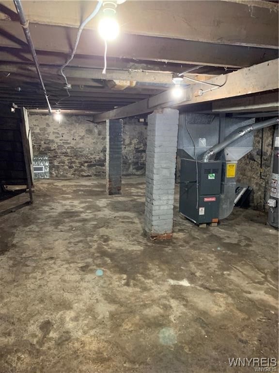 basement featuring gas water heater and heating unit