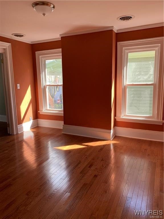 unfurnished room with hardwood / wood-style flooring and crown molding