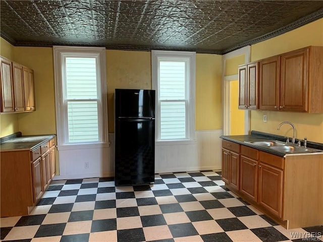 kitchen with black fridge, sink, and a healthy amount of sunlight