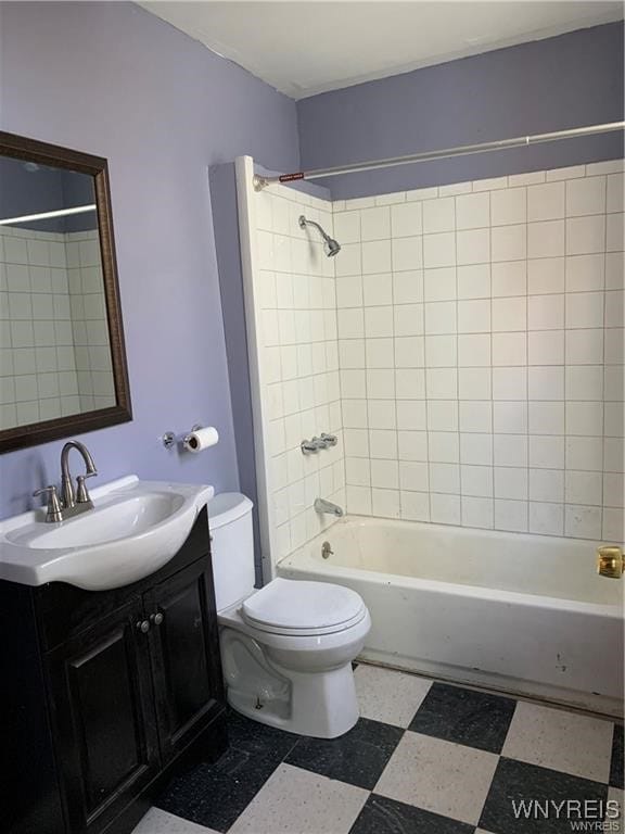 full bathroom with tiled shower / bath, vanity, and toilet