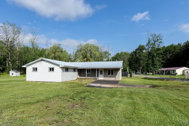 rear view of property featuring a yard and a shed