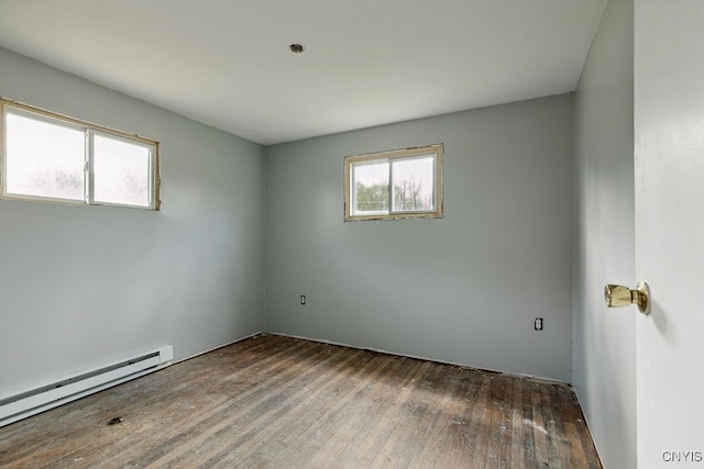 spare room with wood-type flooring and a baseboard radiator