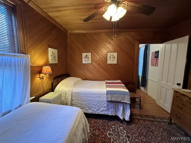 bedroom with wood walls, wooden ceiling, and ceiling fan