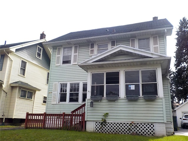 rear view of property featuring a sunroom