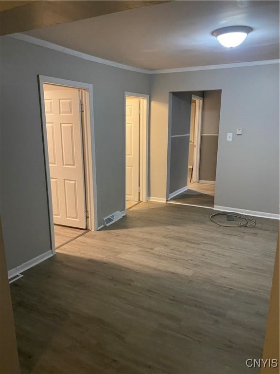 spare room with hardwood / wood-style flooring and crown molding